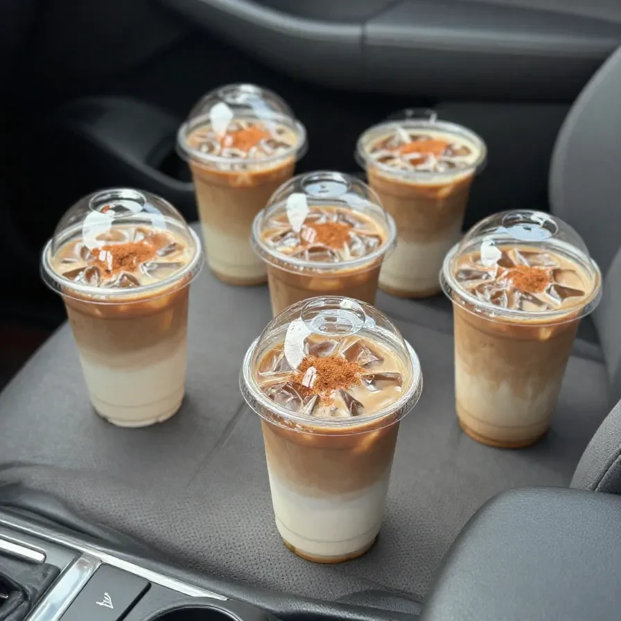 A steaming mug of vegan pumpkin spice coffee topped with dairy-free foam and a sprinkle of cinnamon on a cozy autumn table
