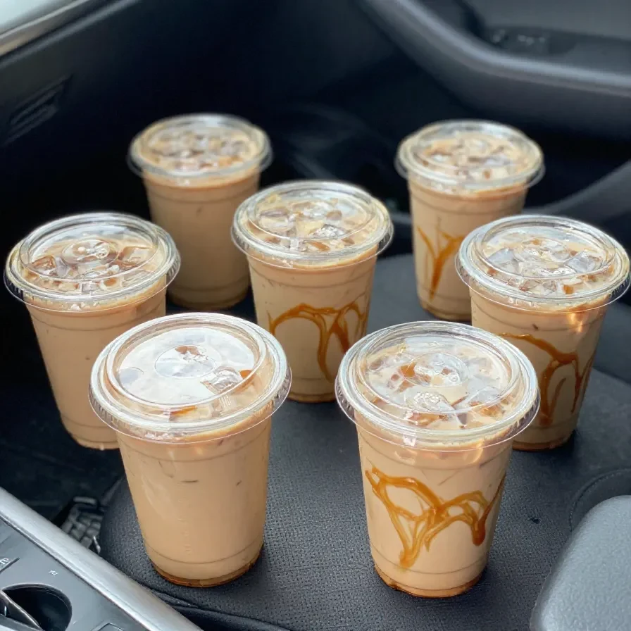 A Starbucks iced pumpkin spice chai latte served in a clear cup with ice and creamy foam on top.
